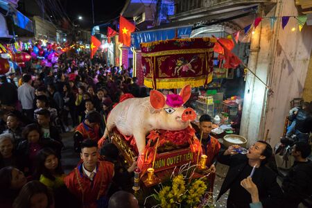 Hanoi, Vietnam - Feb 9, 2017: Pig procession festival in La Phu village. People wearing formal...
