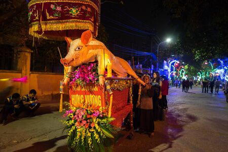 Hanoi, Vietnam - Feb 9, 2017: Pig procession festival in La Phu village. People wearing formal uniform and going from the main path of the village to the temple.のeditorial素材