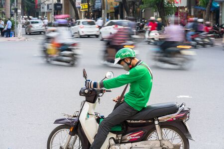 Hanoi, Vietnam - July 7, 2017: Grab motorbike driver waiting for customer on Ba Trieu street. Entered Vietnam in 2014, Grab growing fast due to cheap fare and safer than traditional motorbike taxiのeditorial素材