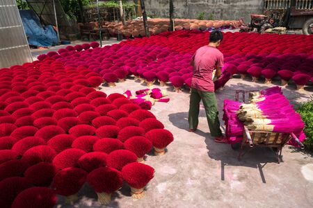 Hanoi, Vietnam - July 28, 2017: Incense sticks drying outdoor with Vietnamese worker working on the yardのeditorial素材