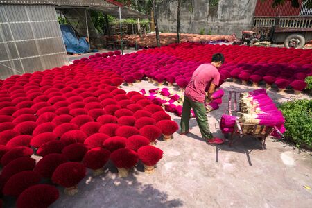 Hanoi, Vietnam - July 28, 2017: Incense sticks drying outdoor with Vietnamese worker working on the yardのeditorial素材