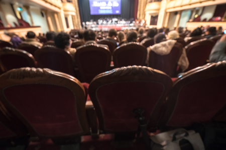 Blurred Audience in a theater, on a concert. Viewers watching the show.の写真素材