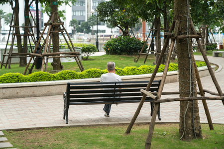 Senior man are sitting on a park benchの写真素材