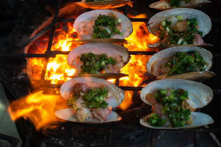 Grilled Oysters on fire with oil, green onion, roasted peanutの写真素材