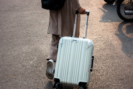 Woman tourist walking with suitcase on the street. Travel conceptの写真素材