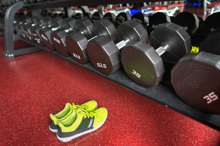 Fitness dumbbells with sport shoes in gymの写真素材