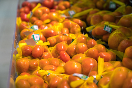 Fresh healthy fruits on shelves in supermarket. Ripe tomatoの写真素材