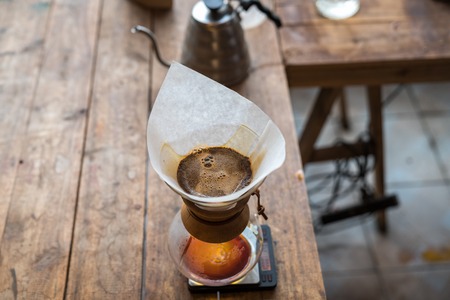 Hand drip coffee, hot water on coffee ground with filterの写真素材
