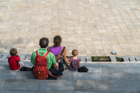 Family members sitting on square in Sapa on vacation in Vietnam. Backpack travel. Large family member.の写真素材
