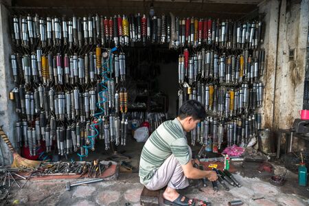 Hanoi, Vietnam - July 10, 2018: Many old shock absorbers hanging at a repair shop on Hanoi street, Vietnamのeditorial素材