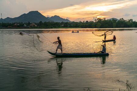 Chau Doc, Vietnam - Oct 14, 2018: Fisher men fishing on a fishing boat in river in Mekong Delta on floating water season at sunsetのeditorial素材