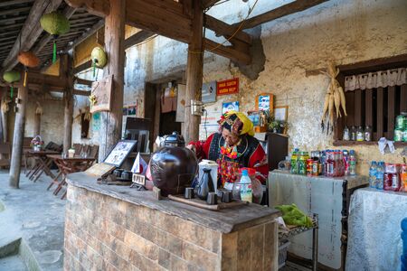 Ha Giang, Vietnam - Nov 27, 2018: Ethnic minority Lo Lo old woman making coffee at old wall-thicked house in Dong Van. Ethnic groups have adapted to new culture and lifestyle for modern lifeのeditorial素材
