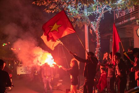 Hanoi, Vietnam - Dec 16, 2018: Crowd of Vietnamese football fans down Hanoi street to celebrate the win after soccer, with a lot of Vietnamese flags raising highのeditorial素材