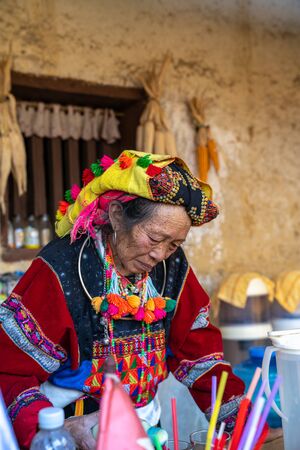 Ha Giang, Vietnam - Nov 27, 2018: Ethnic minority Lo Lo old woman making coffee at old wall-thicked house in Dong Van. Ethnic groups have adapted to new culture and lifestyle for modern lifeのeditorial素材