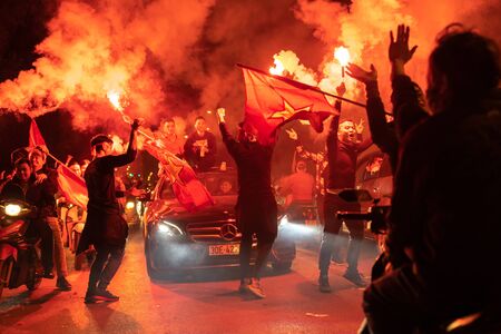 Hanoi, Vietnam - Dec 16, 2018: Crowd of Vietnamese football fans down Hanoi street to celebrate the win after soccer, with a lot of Vietnamese flags raising highのeditorial素材