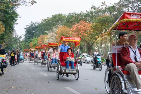 Hanoi, Vietnam - Feb 13, 2019: Hanoi street in fall season with yellow red leaves on branches. The "leaf change" seasonのeditorial素材