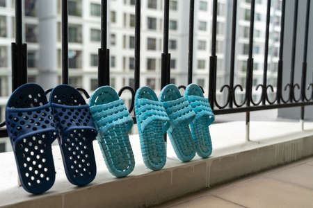 Slippers, washed and then dried in the sun in balcony of apartment buildingの写真素材