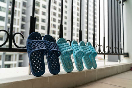 Slippers, washed and then dried in the sun in balcony of apartment buildingの写真素材