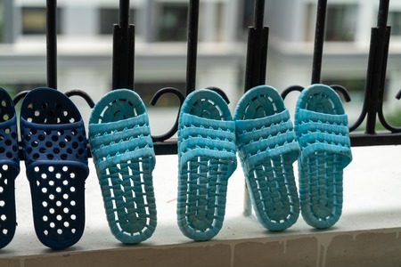 Slippers, washed and then dried in the sun in balcony of apartment buildingの写真素材