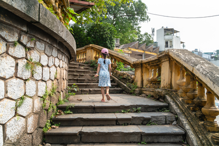 Old open outer stone staircase, aged footpath in Hanoi city with a child running up on stepsのeditorial素材