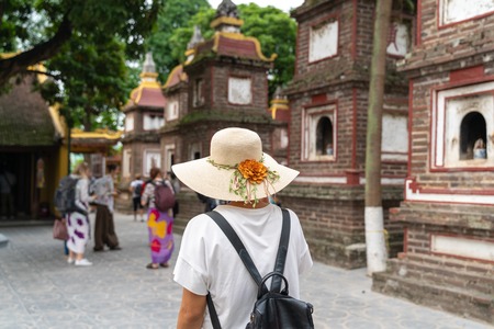 Close-up female tourist visiting Tran Quoc ancient pagoda, the oldest Buddhist temple in Hanoi, Vietnamのeditorial素材