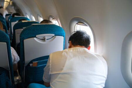 Passenger traveler in airplane, travel by flight, man tourist sitting in air planeの写真素材