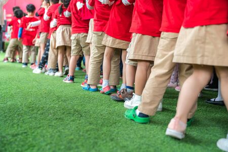 Queue of Asian kids in school uniform standing in lineの写真素材