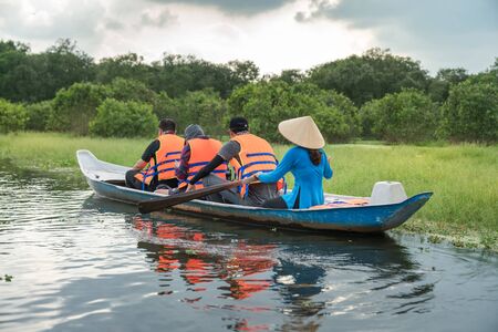 Tourism rowing boat in cajuput forest in floating water season in Mekong delta, Vietnamの写真素材
