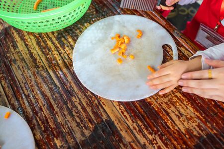 Asian school kids learn to cut vegetable in cooking class closeupの写真素材