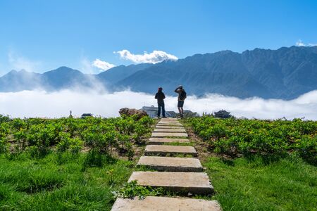Mountain and low clouds view with stone walking steps and traveller taking landscape photo in Sapa town, Vietnamの写真素材
