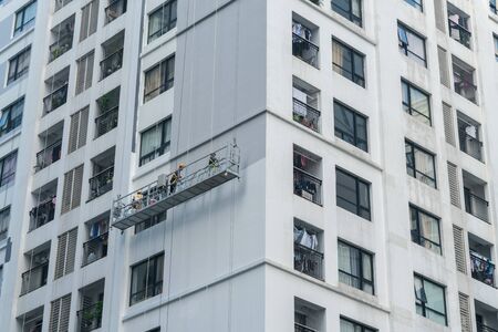 Apartment building with a group of worker painting building exteriorの写真素材