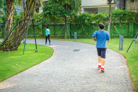 Urban walking road among green trees inside modern apartment building area in big cityの写真素材