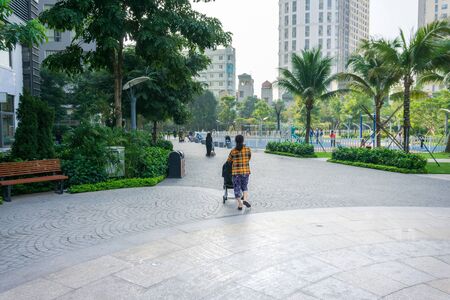Urban walking road among green trees inside modern apartment building area in big cityの写真素材