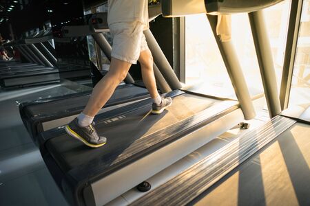 Machine treadmill with people running closeup at fitness gymの写真素材
