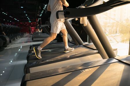 Machine treadmill with people running closeup at fitness gymの写真素材