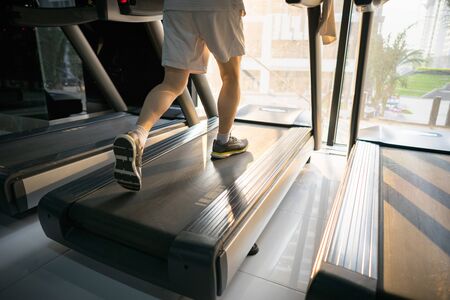 Machine treadmill with people running closeup at fitness gymの写真素材