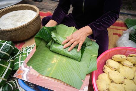 Making Chung cake by female craftsman closeup. Traditional Vietnamese New Year Tet food.の写真素材