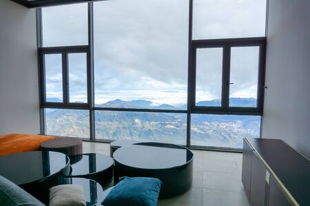 Hotel room with mountain landscape view from window, interiors with chairs and tableの写真素材