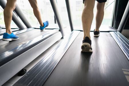 Gym treadmill closeup with man legs running. Concept for exercising, fitness and healthy lifestyleの写真素材