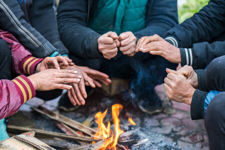 Hands of rural minority people warming up around the fire during the cold weather days in mountaious region in Vietnamの写真素材