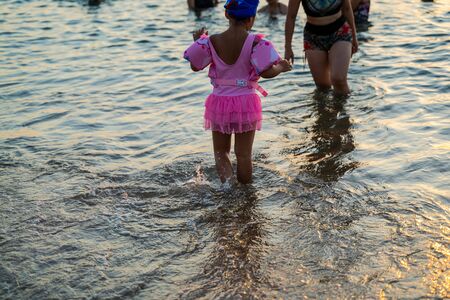 Little girl in pink skirt playing on the beachの写真素材