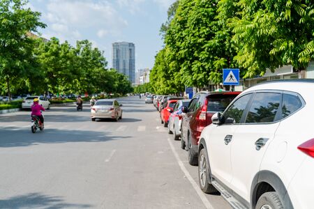 Cars parked on the urban street side, with green tree line. Green city conceptの写真素材