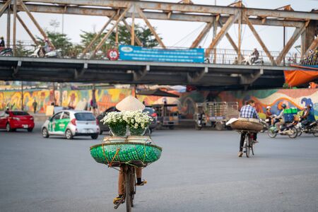 Flower vendor on Hanoi street at early morning with Long Bien old metal bridge on backgroundの写真素材