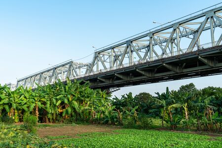 Chuong Duong bridge crossing above green cultivated farmland in Hanoi, Vietnamの写真素材