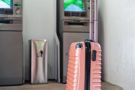 Travel luggage with ATM on background. Vacation financing, travel money conceptの写真素材