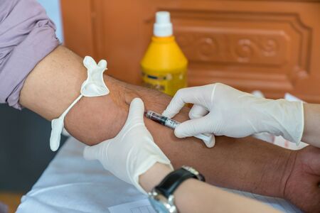Volunteer nurse taking blood sample from poor patient in Vietnam