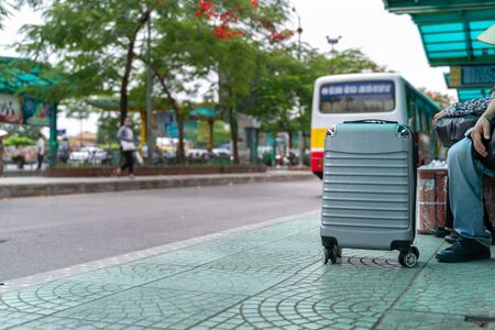 Luggage of a traveller at bus stop with the bus on backgroundの写真素材