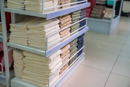 Stacks of colored towels on the shelves in supermarketの写真素材