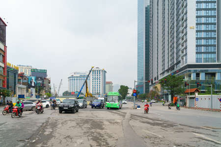 Hanoi, Vietnam - Mar 12, 2020: Kim Ma street with vehicles running on street, growing building and under construction building on backgroundのeditorial素材