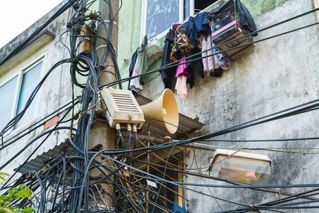 Public loudspeaker with surrounded electrical wires in old town of Hanoiの写真素材